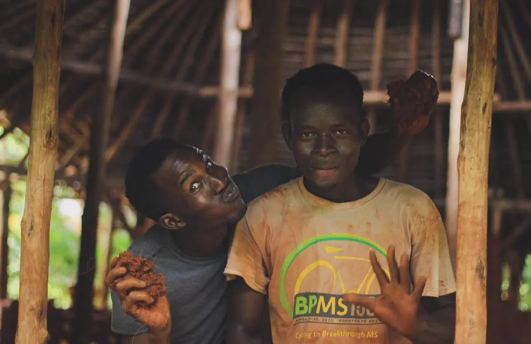 Two participants building with an earth-based material