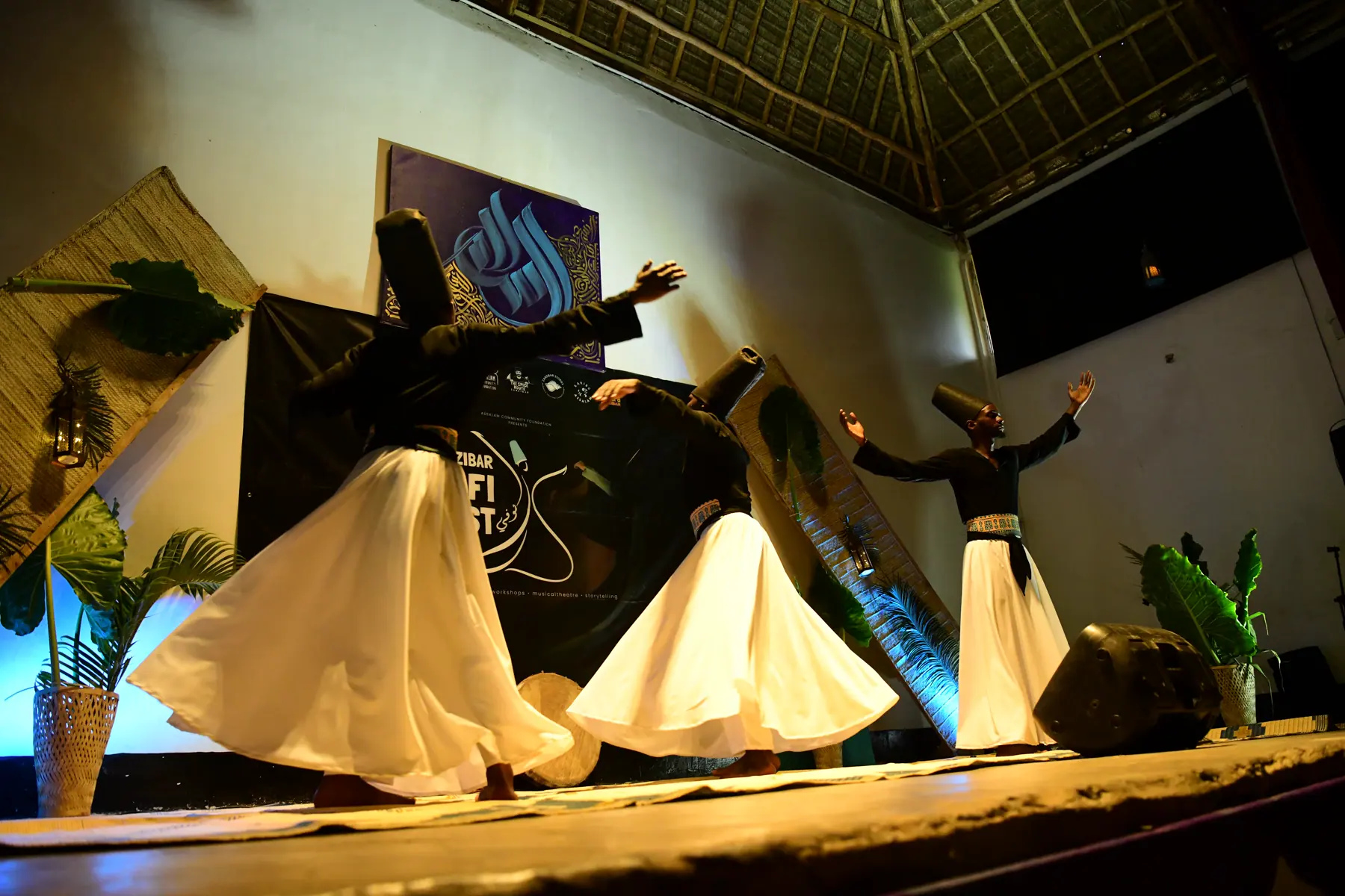 Sawa Ensemble performers dancing in white whirling skirts on stage