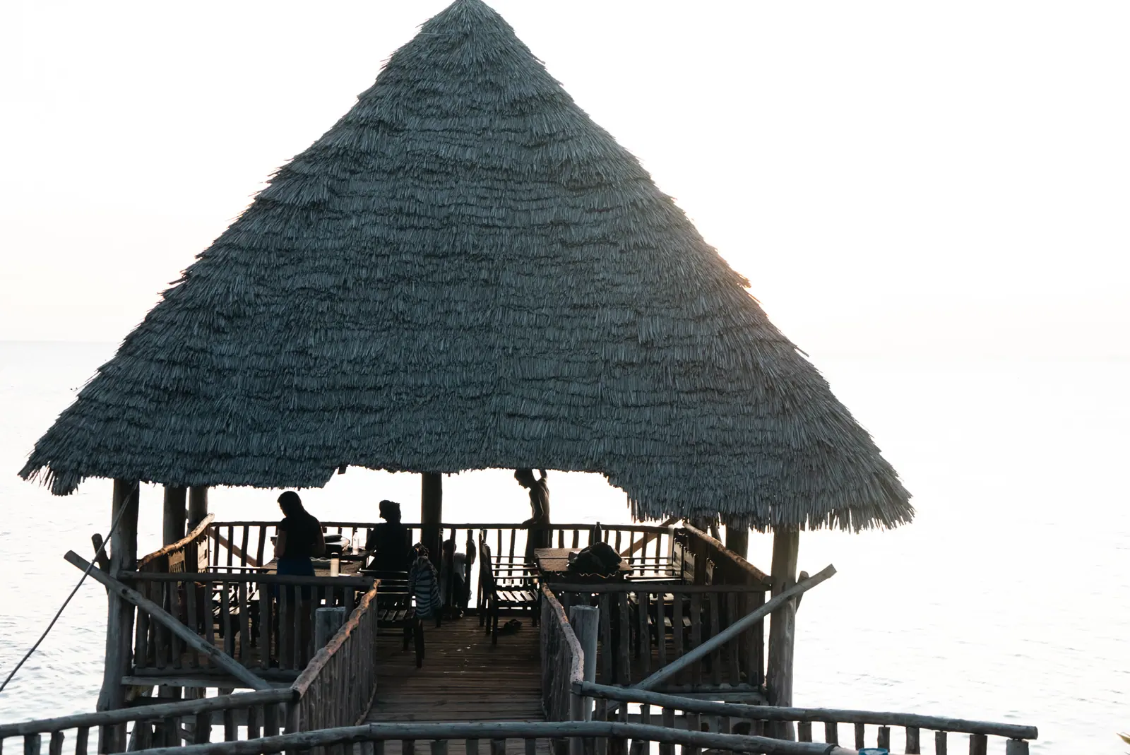 Community gathered inside an open-sided Makuti pavilion by the sea