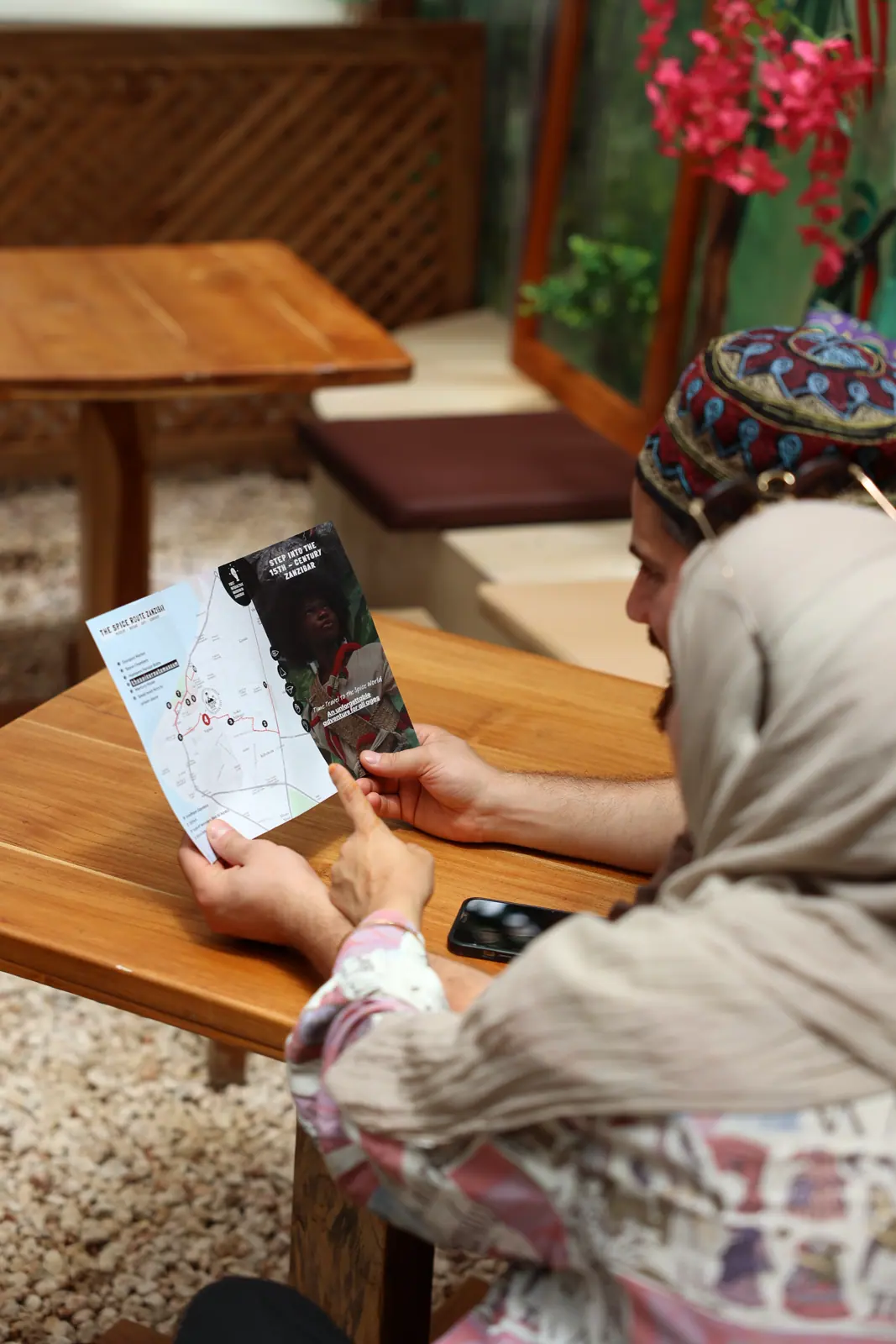 Visitor reading an illustrated museum guide at a low table