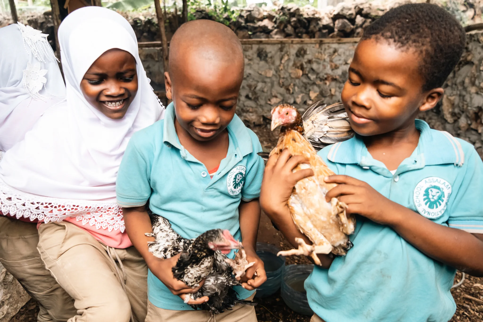 Young learners holding chickens during an animal-care activity