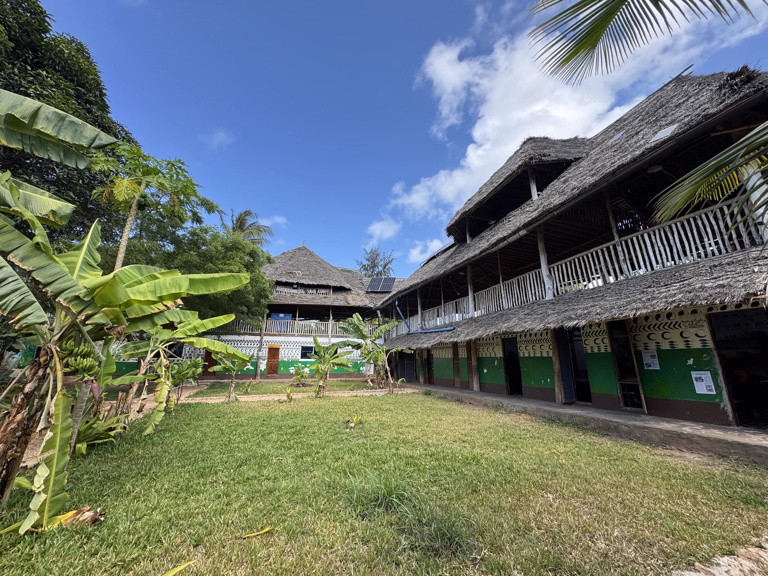 A Makuti-roofed school courtyard with solar panels at Assalam
